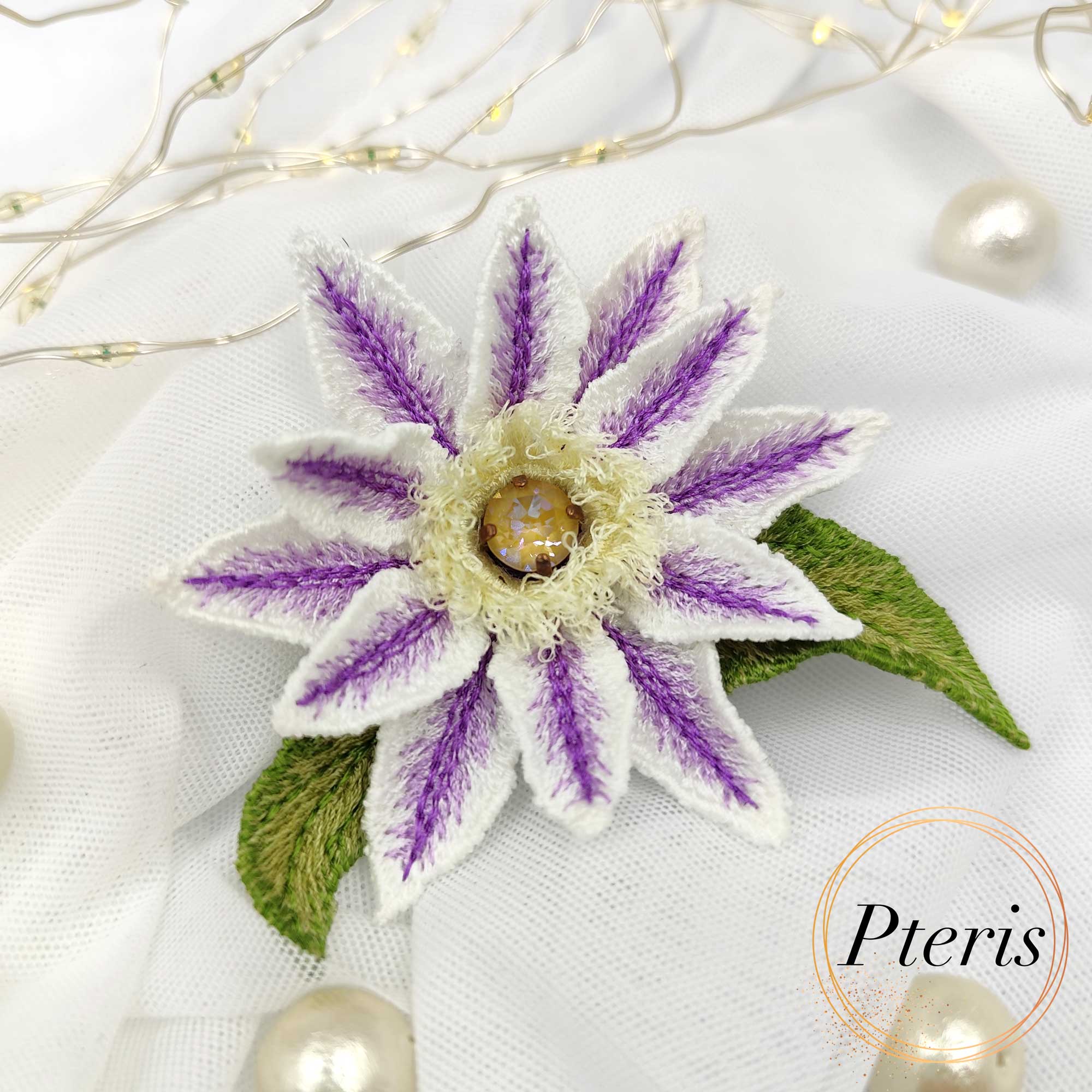 3D Clematis Embroidery Design for FSL brooch featuring white petals with purple striped details, a yellow textured center, and green leaves.