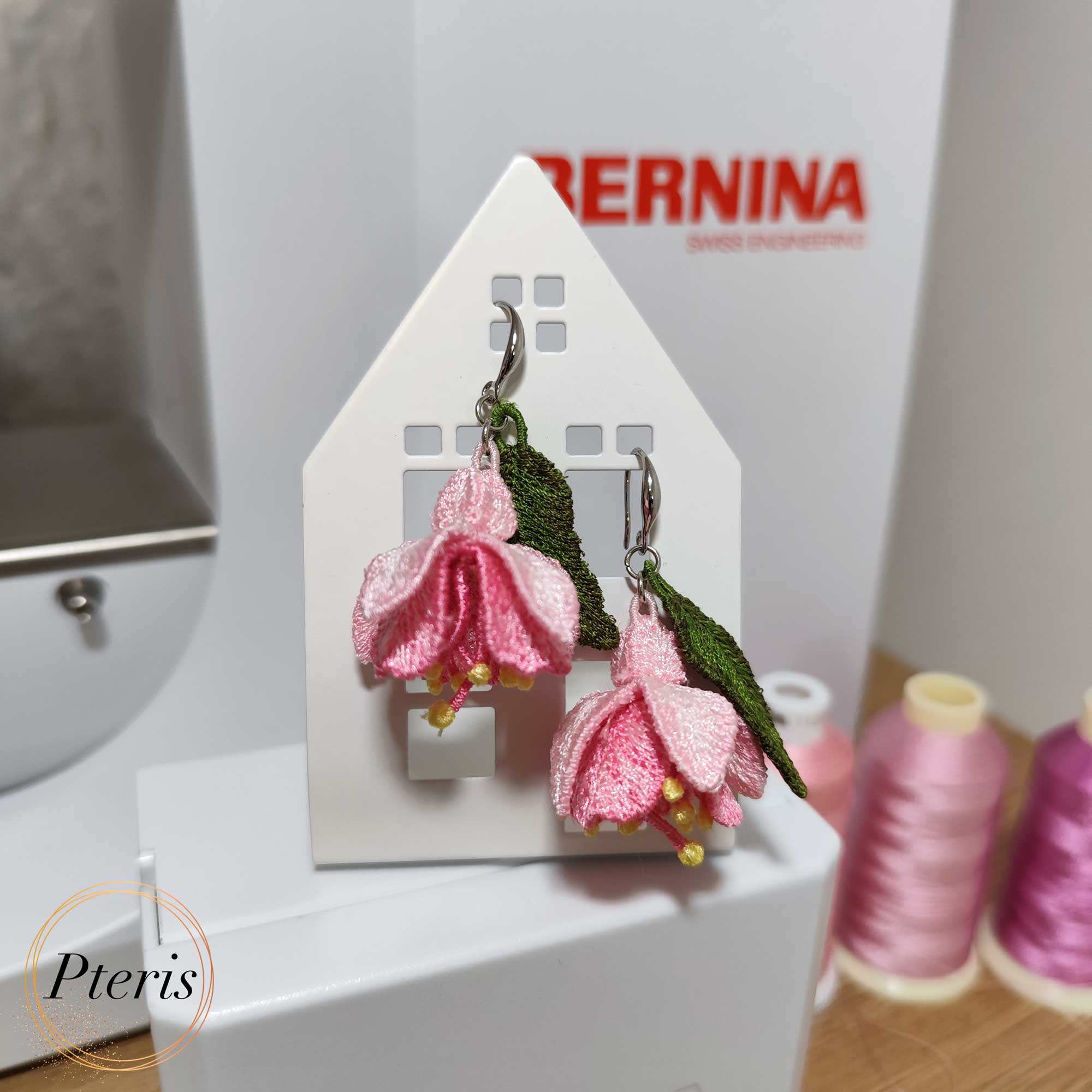 FSL 3D Fuchsia flower earrings machine embroidery design featuring pink petals and green leaves on silver hooks.