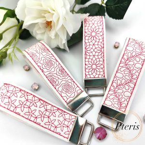 ITH Quilted Floral Key Fob embroidery design on white faux leather with pink stitching