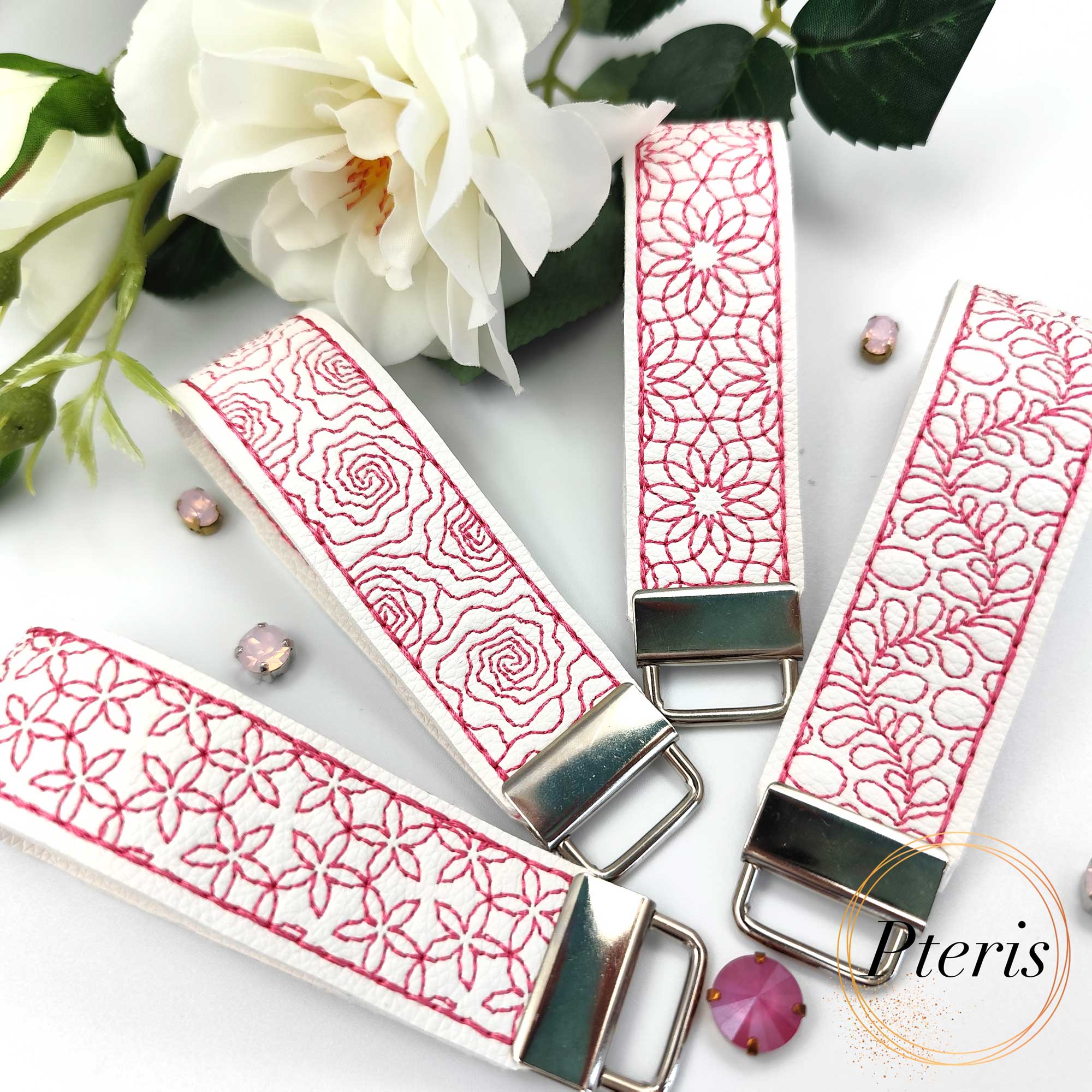 ITH Quilted Floral Key Fob embroidery design on white faux leather with pink stitching