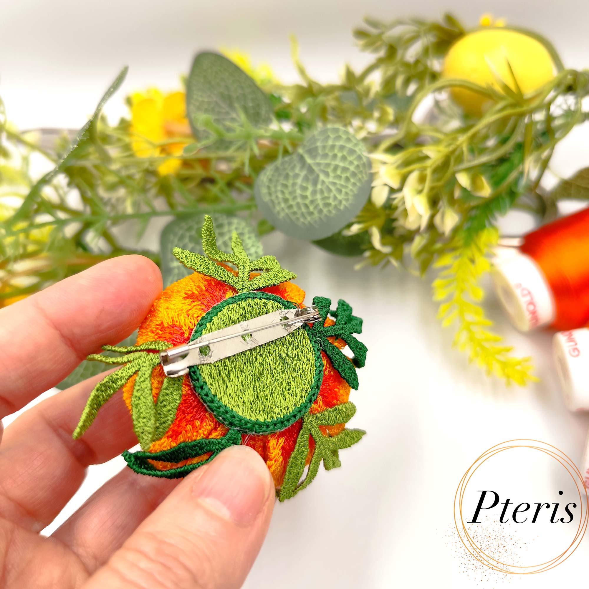3D Marigold Embroidery Design for FSL brooch featuring layered orange and yellow ruffled petals with dark green leaves.