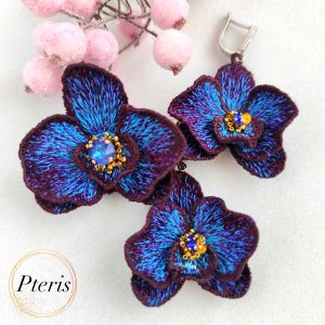 FSL 3D Orchid earrings and brooch machine embroidery design featuring dark purple and bright blue gradient petals with a central crystal accent.