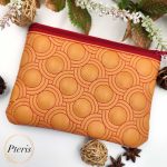 ITH Concentric Circle Zipper Pouch embroidery design with red stitching on tan leather