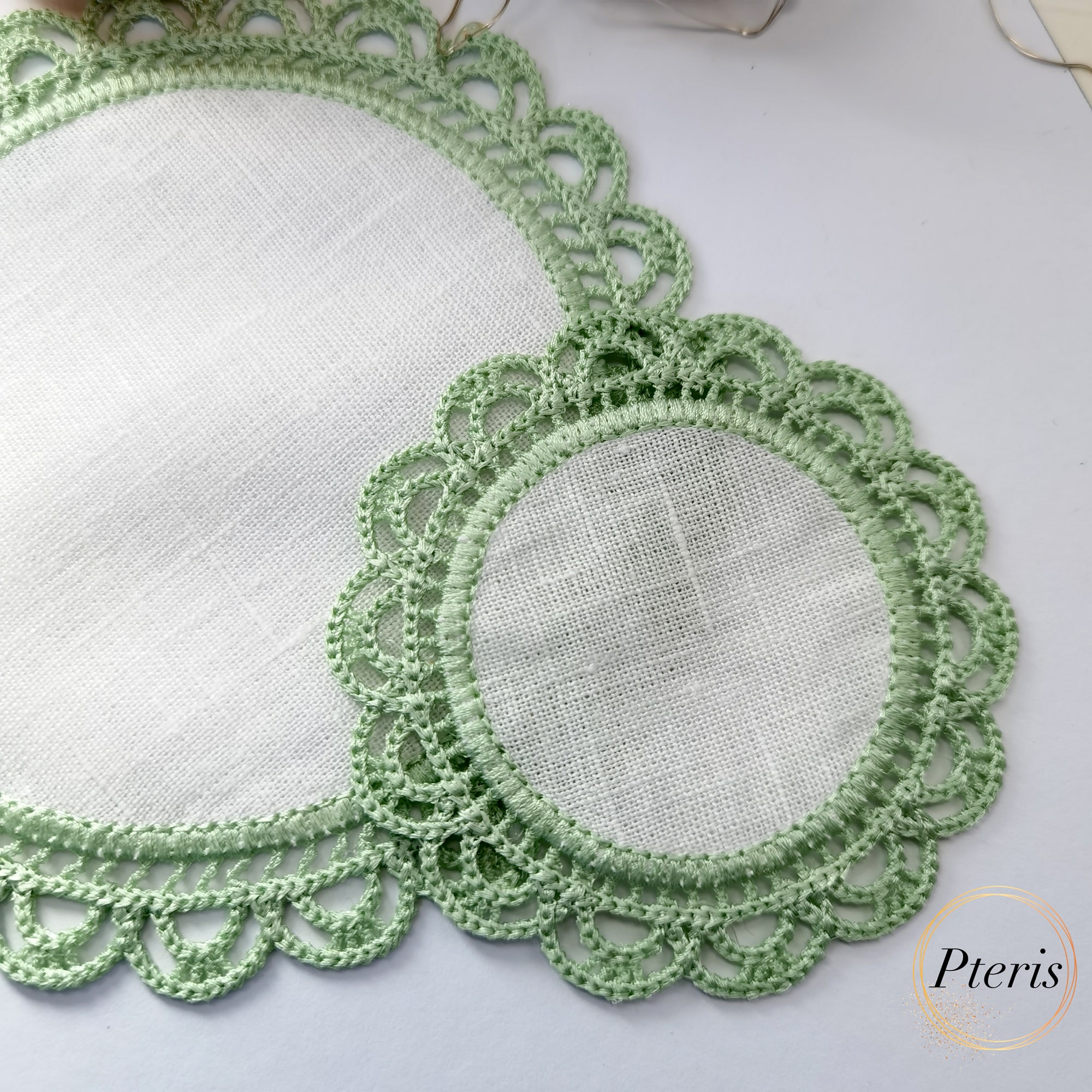 FSL Crochet Style Napkin Design featuring two light green lace coasters with white fabric centers, styled with Christmas ornaments and fairy lights.