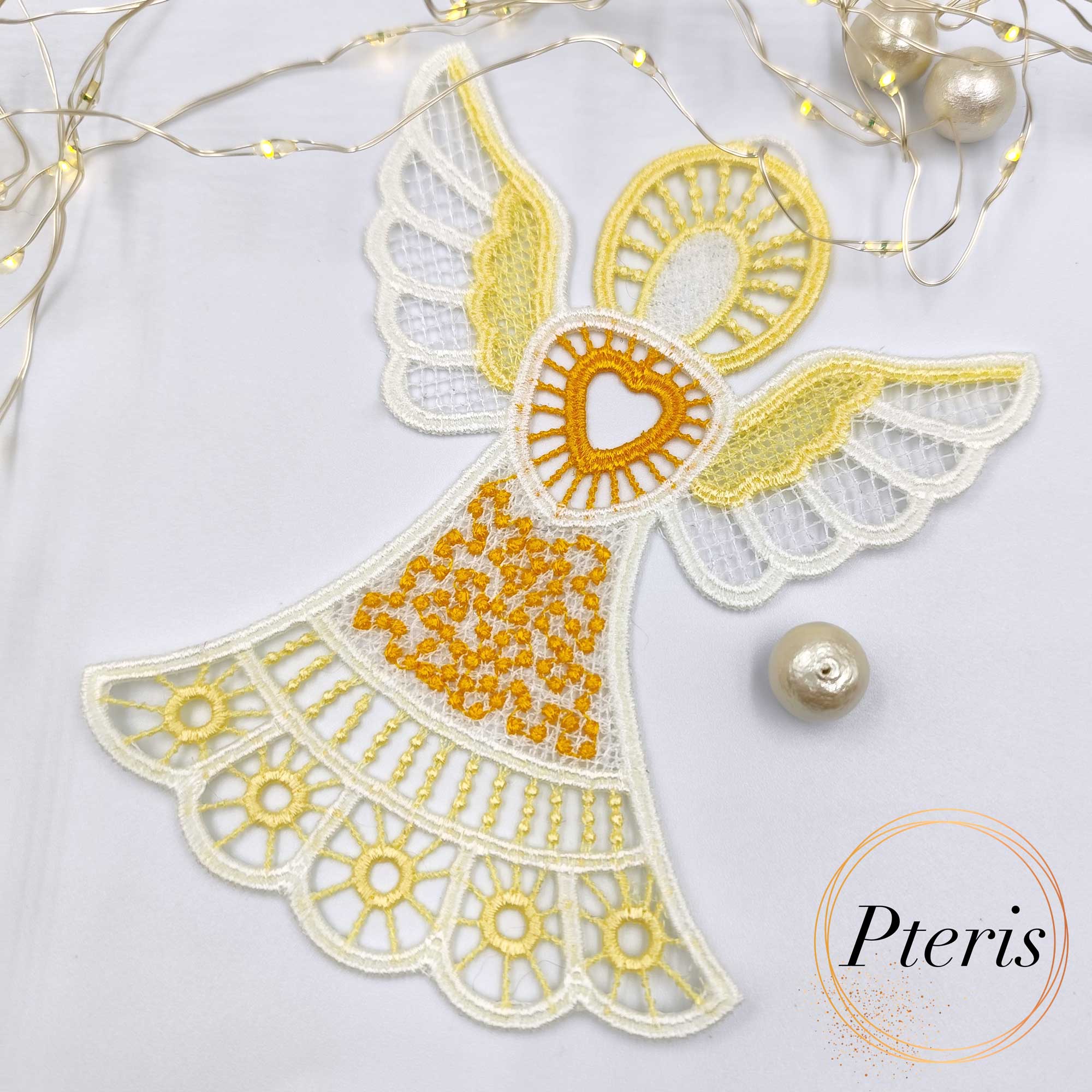 FSL Lace Angel Suncatcher embroidery design featuring a white and yellow freestanding lace angel with a heart at its center, styled with fairy lights and pearls on a white background.