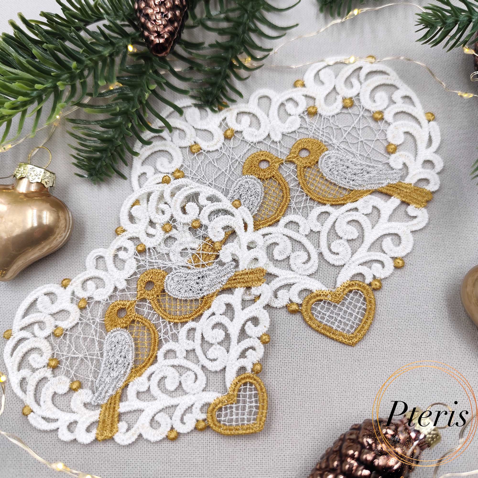 FSL Lace Bird Suncatcher Design featuring white and gold freestanding lace hearts with birds, styled with white blossoms, pearls, and a gold velvet ribbon.