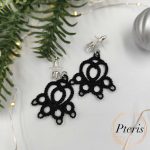 FSL Cat Paw Earrings Embroidery Design showing a pair of black tatting-style lace earrings shaped like cat paws on a white background with decorative leaves and berries.