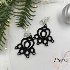 FSL Cat Paw Earrings Embroidery Design showing a pair of black tatting-style lace earrings shaped like cat paws on a white background with decorative leaves and berries.
