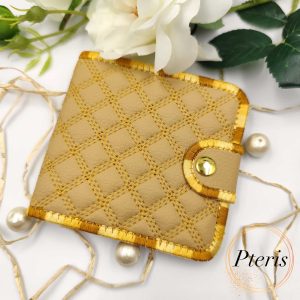 ITH Quilted Wallet embroidery design showing a handmade bifold wallet with blue diamond quilting, credit card slots, and a bill compartment, styled with a blue thread spool.