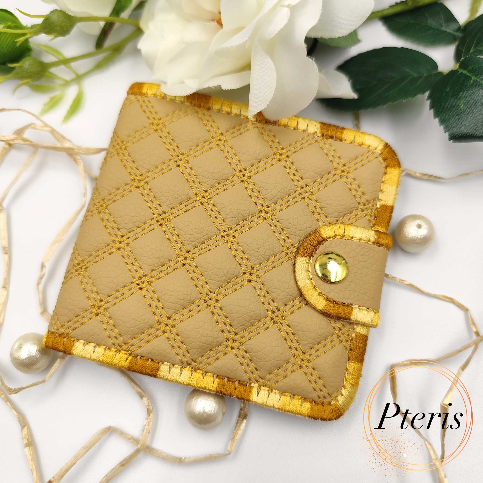 ITH Quilted Wallet embroidery design showing a handmade bifold wallet with blue diamond quilting, credit card slots, and a bill compartment, styled with a blue thread spool.
