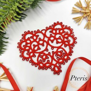FSL Tatting Heart Pendant Design featuring a bright red freestanding lace heart ornament suspended by a ribbon, surrounded by festive evergreen branches and straw stars.