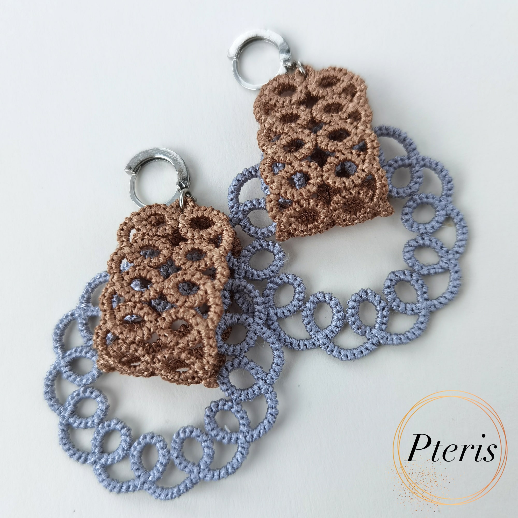 FSL Tatting Earrings Embroidery Design showing a pair of intricate freestanding lace earrings with brown top elements and blue-grey looped lace bottoms.