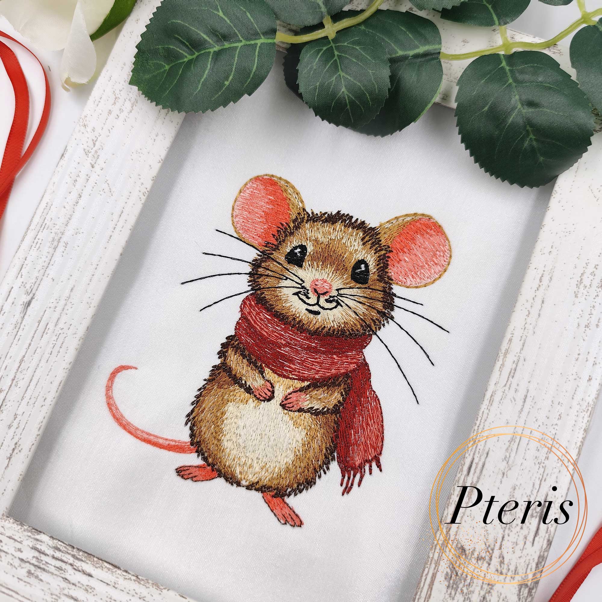 Cute Mouse Embroidery Design showing an adorable brown field mouse with large pink ears, dark sparkling eyes, and a cream belly, wearing a cozy textured red scarf wrapped around its neck, embroidered on a clean white fabric sample.