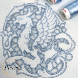 Regal Gryphon machine embroidery design featuring a close-up of an intricate mythical gryphon stitched in light blue-grey thread on white linen fabric, showcasing elegant Richelieu cutwork lace windows.