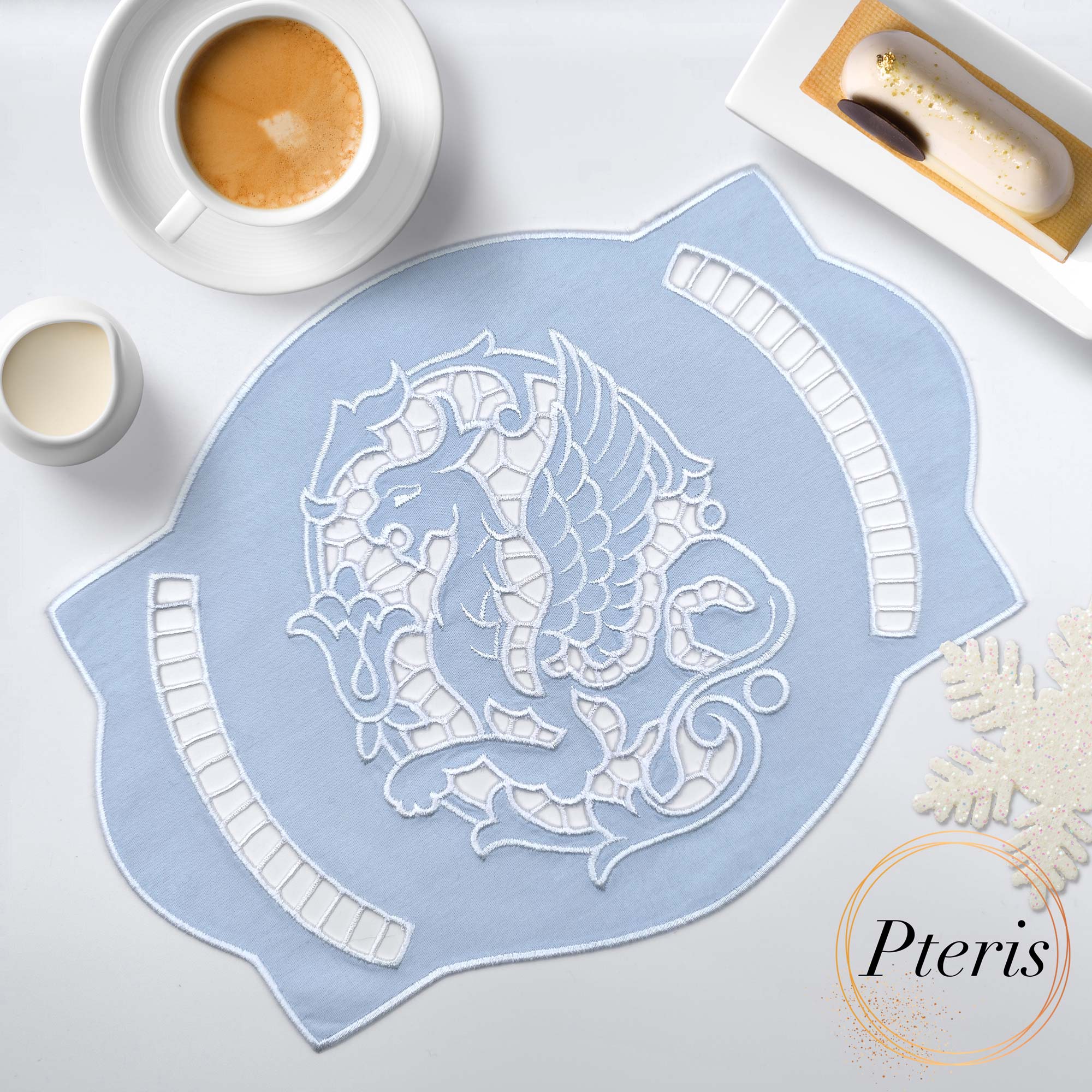 Gryphon Richelieu cutwork doily machine embroidery design featuring an intricate linen table topper with embroidered mythical gryphon motifs and openwork lace arches, styled flat on a dark background.