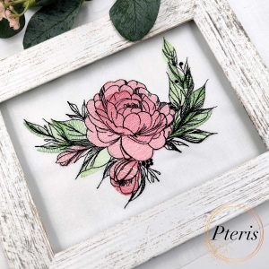 A beautiful sketch-style machine embroidery design of a pink peony flower with detailed black outlines and green leaves, stitched on white fabric and showcased in a rustic white wooden frame, as shown in Peony Embroidery Design